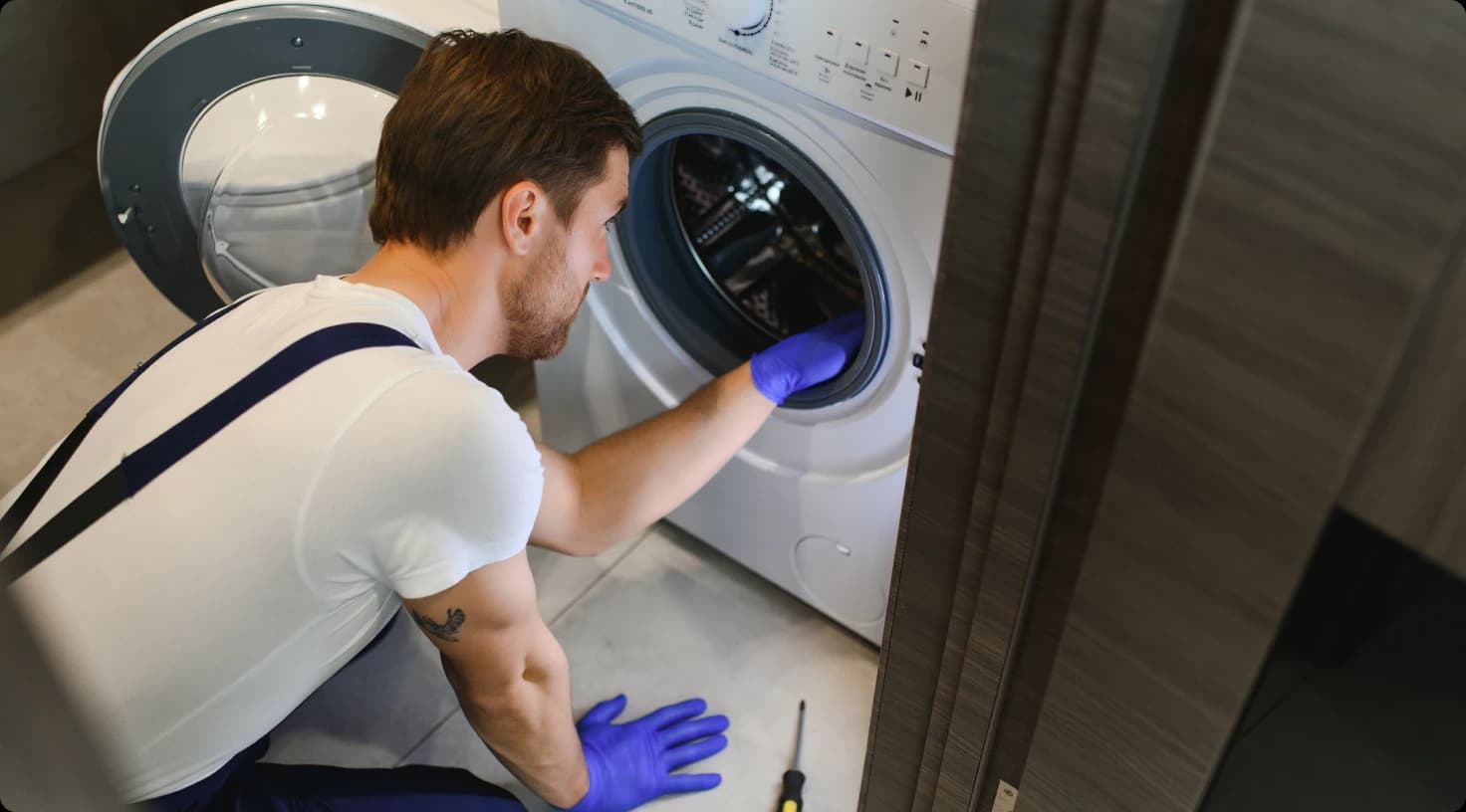 Appliance Repair Technician Fixing Washing Machine